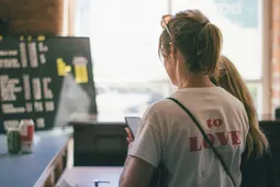 A woman on her phone at a restaurant counter